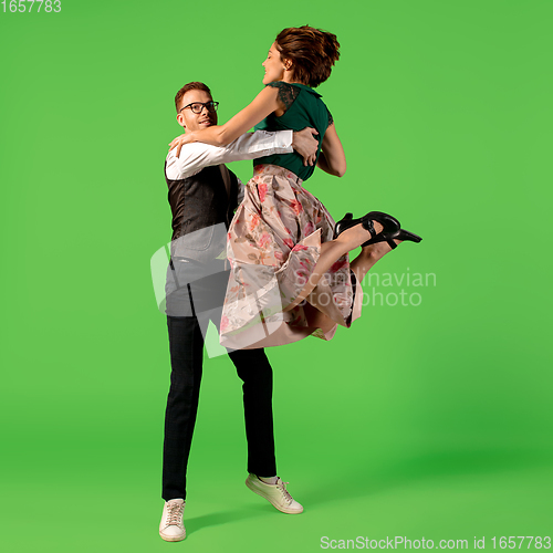 Image of Old-school fashioned young woman dancing isolated on green background