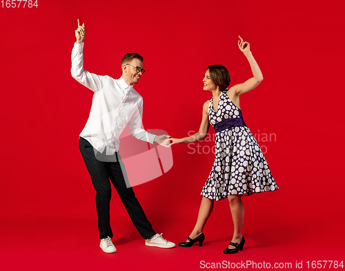 Image of Old-school fashioned young couple dancing isolated on red background