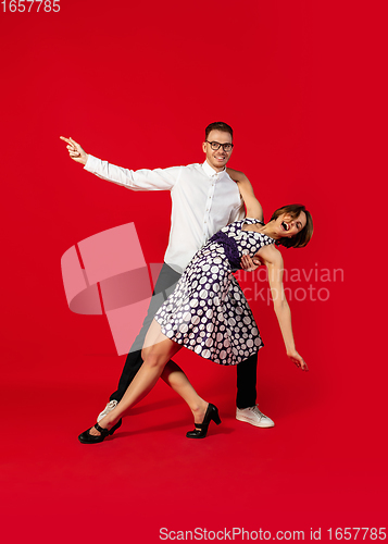 Image of Old-school fashioned young couple dancing isolated on red background