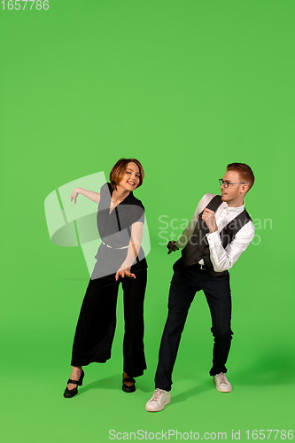 Image of Old-school fashioned young woman dancing isolated on green background