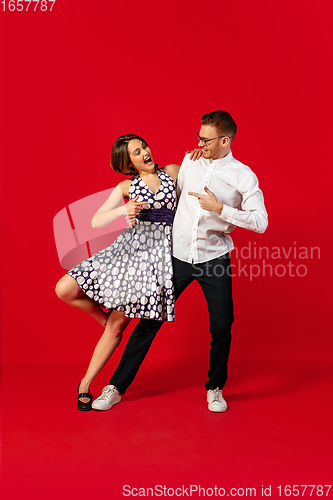 Image of Old-school fashioned young couple dancing isolated on red background