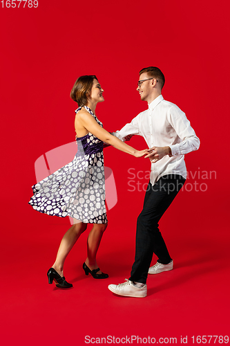 Image of Old-school fashioned young couple dancing isolated on red background