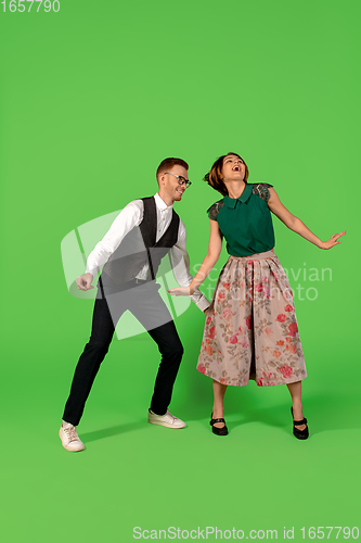 Image of Old-school fashioned young woman dancing isolated on green background