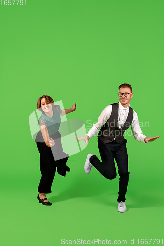 Image of Old-school fashioned young woman dancing isolated on green background