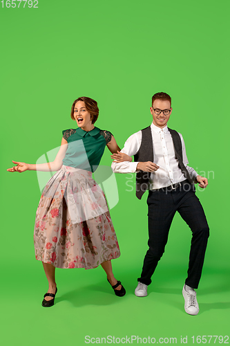 Image of Old-school fashioned young woman dancing isolated on green background