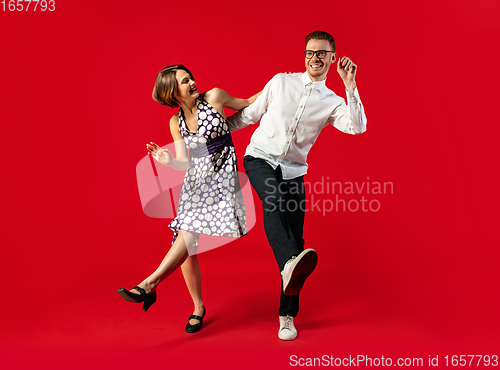 Image of Old-school fashioned young couple dancing isolated on red background