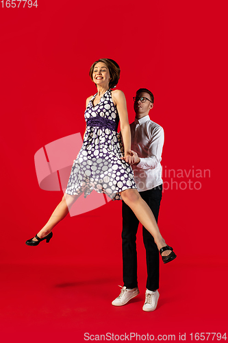 Image of Old-school fashioned young couple dancing isolated on red background