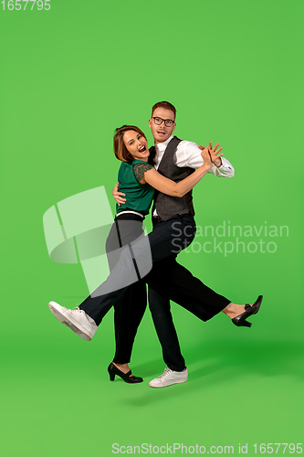 Image of Old-school fashioned young woman dancing isolated on green background