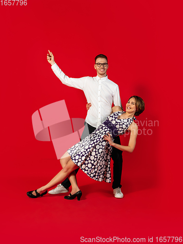 Image of Old-school fashioned young couple dancing isolated on red background