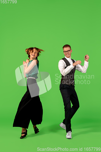 Image of Old-school fashioned young woman dancing isolated on green background