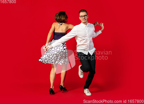 Image of Old-school fashioned young couple dancing isolated on red background