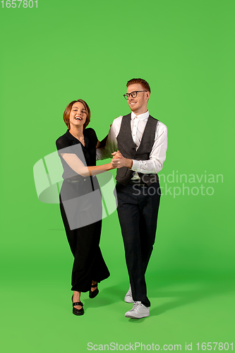 Image of Old-school fashioned young woman dancing isolated on green background