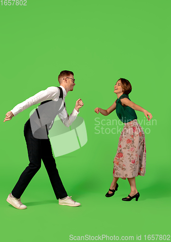 Image of Old-school fashioned young woman dancing isolated on green background