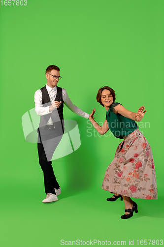 Image of Old-school fashioned young woman dancing isolated on green background