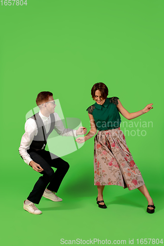 Image of Old-school fashioned young woman dancing isolated on green background