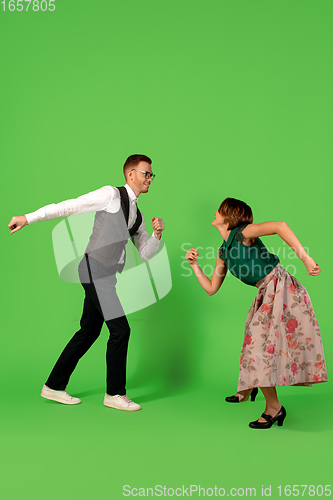 Image of Old-school fashioned young woman dancing isolated on green background