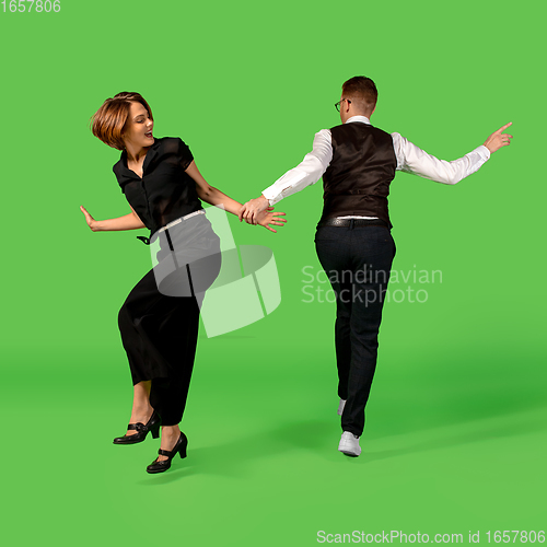 Image of Old-school fashioned young woman dancing isolated on green background