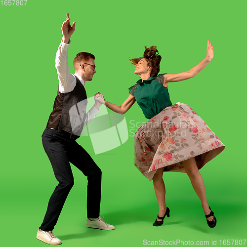 Image of Old-school fashioned young woman dancing isolated on green background