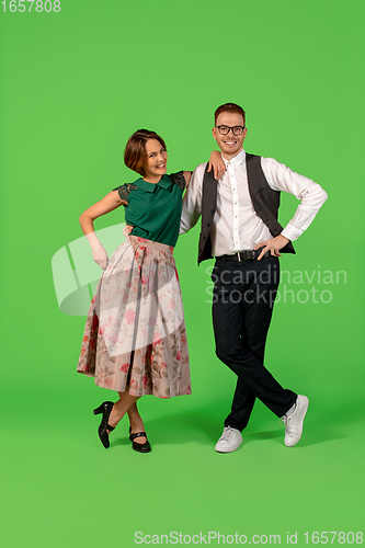 Image of Old-school fashioned young woman dancing isolated on green background