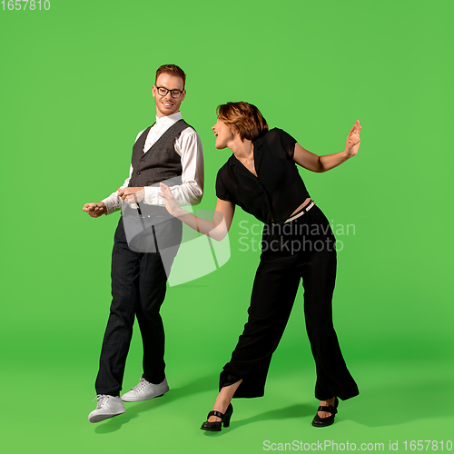 Image of Old-school fashioned young woman dancing isolated on green background