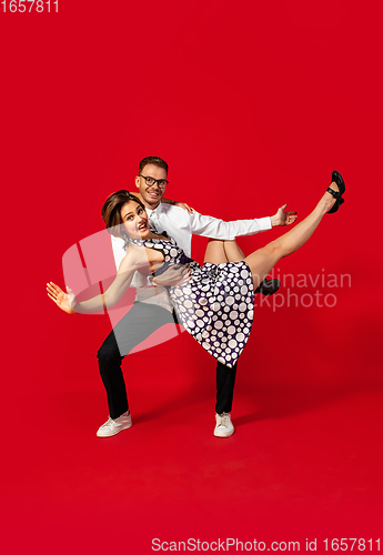 Image of Old-school fashioned young couple dancing isolated on red background