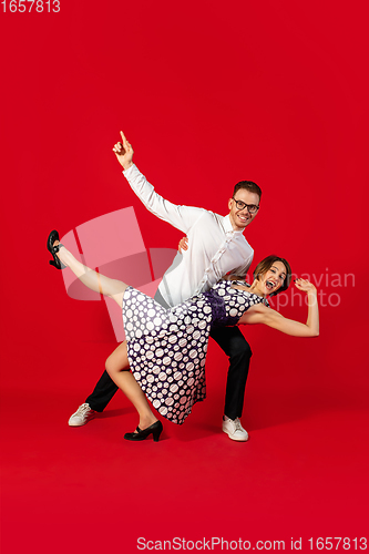 Image of Old-school fashioned young couple dancing isolated on red background