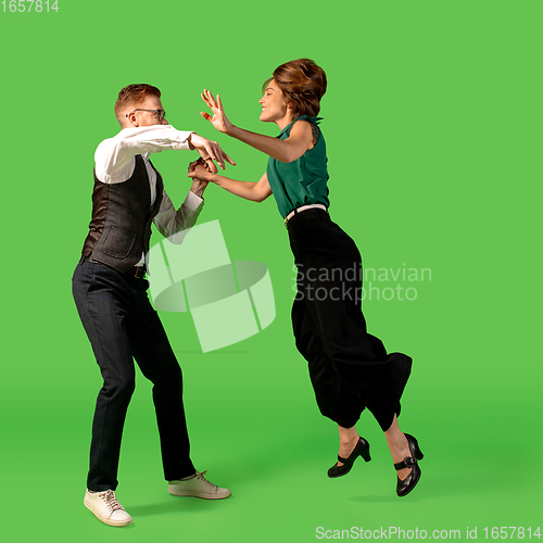 Image of Old-school fashioned young woman dancing isolated on green background