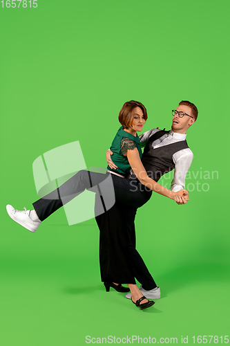 Image of Old-school fashioned young woman dancing isolated on green background