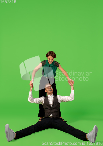 Image of Old-school fashioned young woman dancing isolated on green background