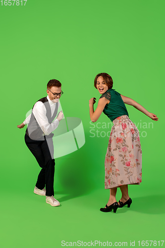 Image of Old-school fashioned young woman dancing isolated on green background