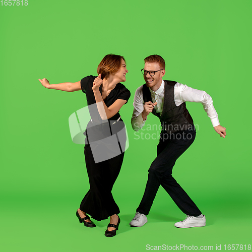 Image of Old-school fashioned young woman dancing isolated on green background