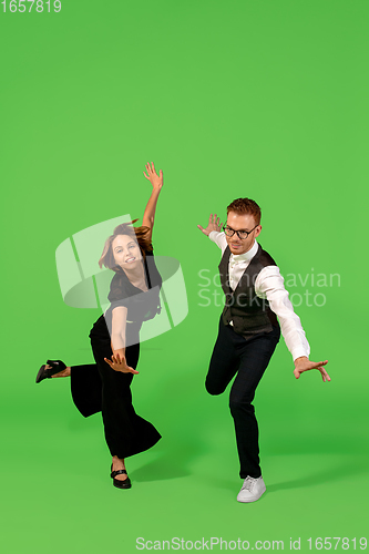 Image of Old-school fashioned young woman dancing isolated on green background