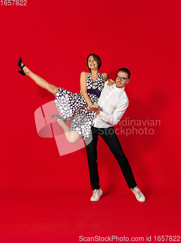 Image of Old-school fashioned young couple dancing isolated on red background