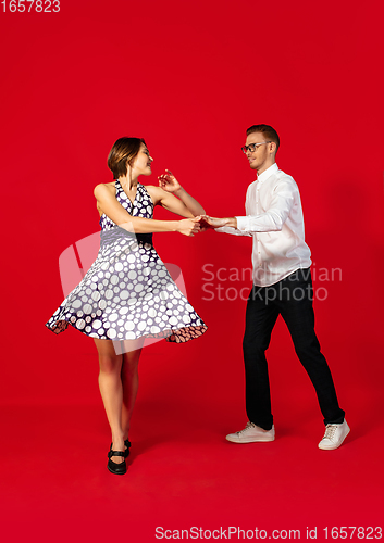 Image of Old-school fashioned young couple dancing isolated on red background