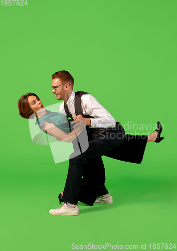 Image of Old-school fashioned young woman dancing isolated on green background