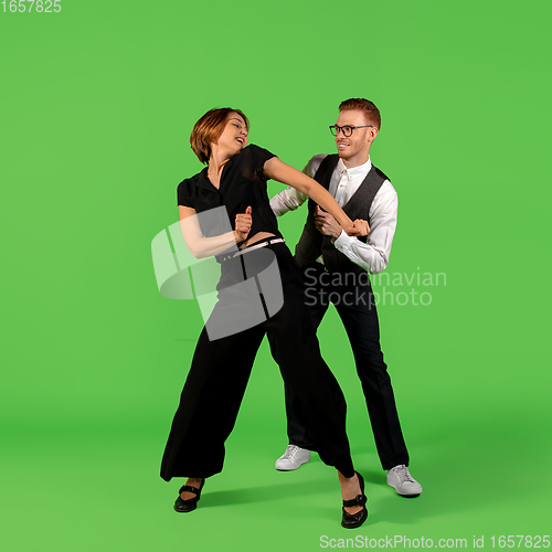 Image of Old-school fashioned young woman dancing isolated on green background