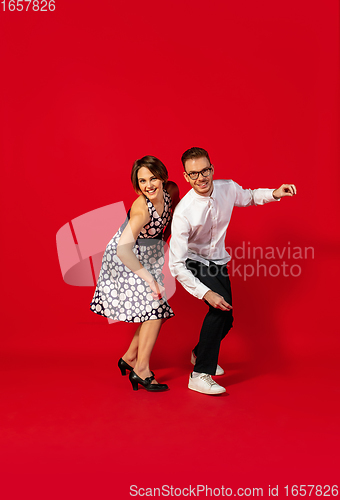 Image of Old-school fashioned young couple dancing isolated on red background