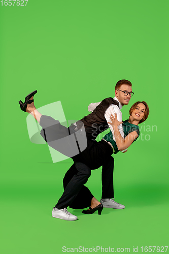 Image of Old-school fashioned young woman dancing isolated on green background