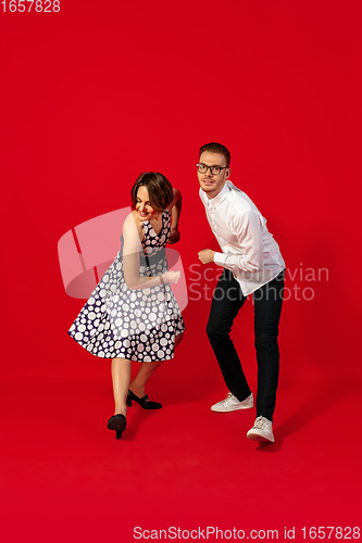 Image of Old-school fashioned young couple dancing isolated on red background