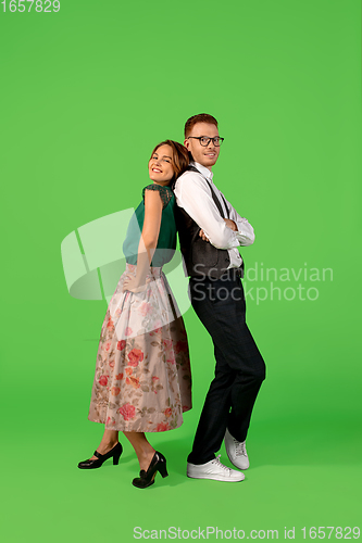 Image of Old-school fashioned young woman dancing isolated on green background