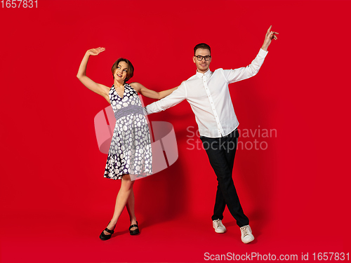 Image of Old-school fashioned young couple dancing isolated on red background