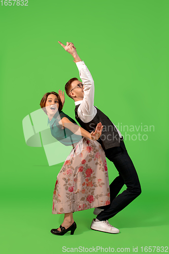 Image of Old-school fashioned young woman dancing isolated on green background