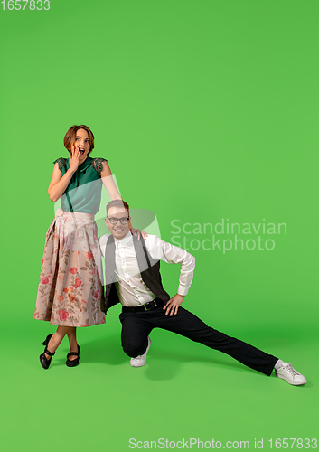 Image of Old-school fashioned young woman dancing isolated on green background