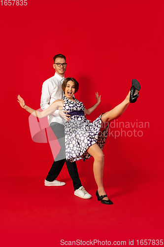 Image of Old-school fashioned young couple dancing isolated on red background