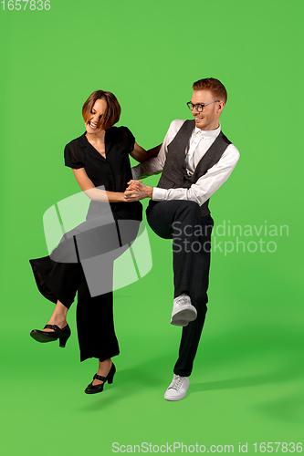 Image of Old-school fashioned young woman dancing isolated on green background