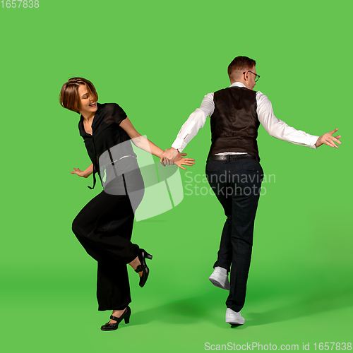 Image of Old-school fashioned young woman dancing isolated on green background