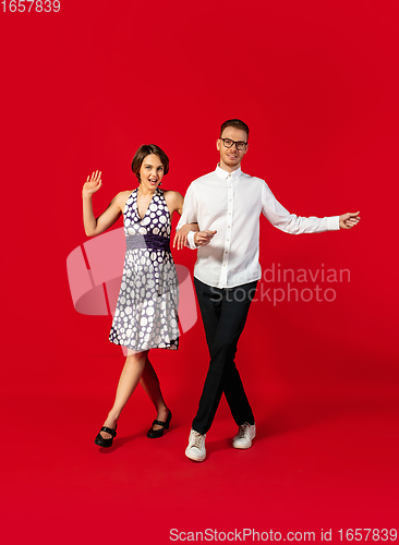 Image of Old-school fashioned young couple dancing isolated on red background