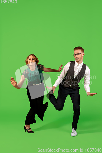 Image of Old-school fashioned young woman dancing isolated on green background