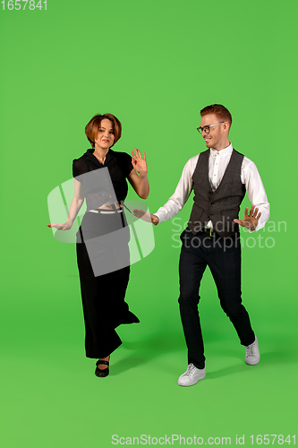 Image of Old-school fashioned young woman dancing isolated on green background