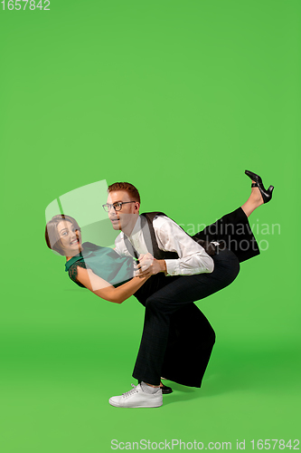 Image of Old-school fashioned young woman dancing isolated on green background